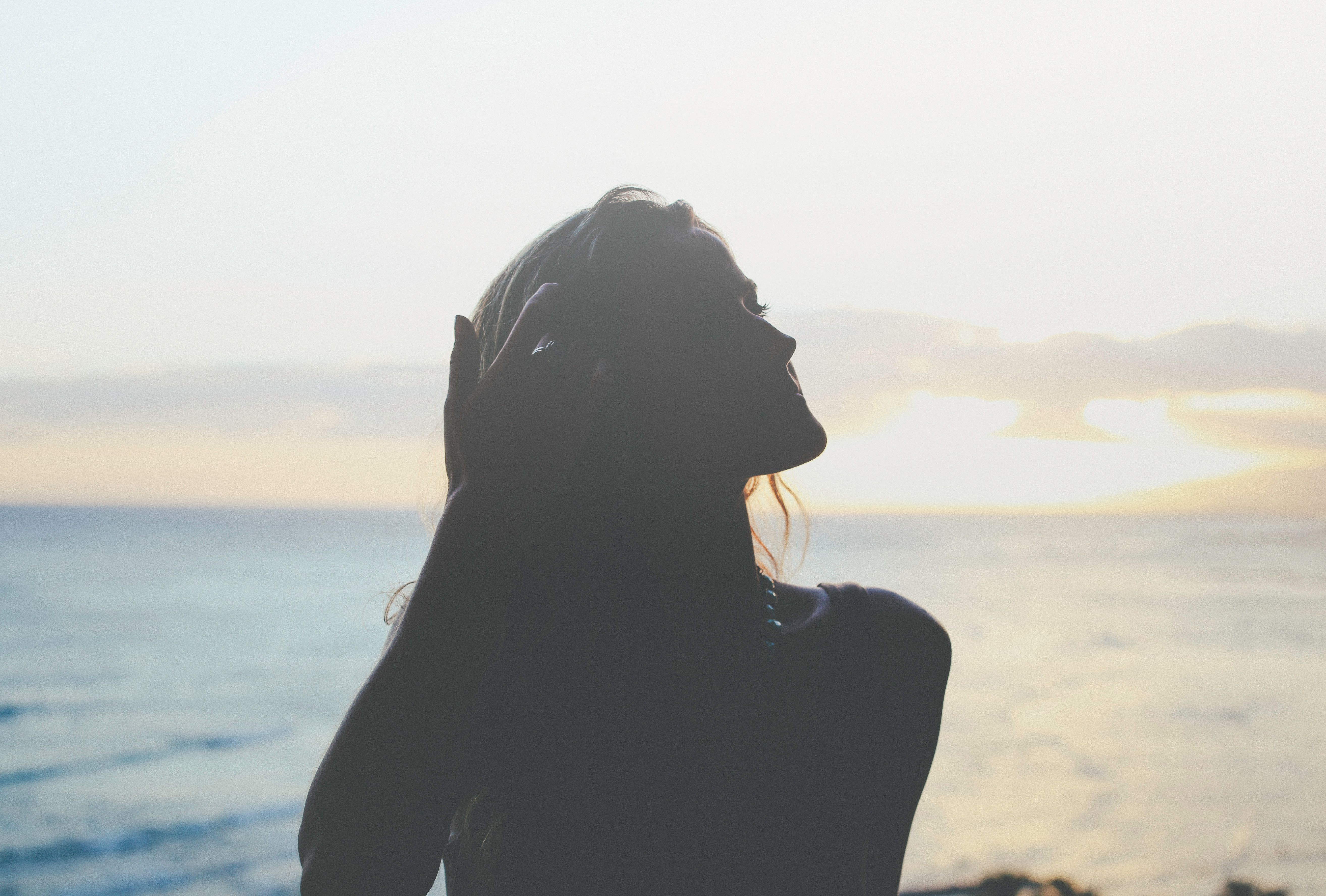 woman overlooking sea at sunset