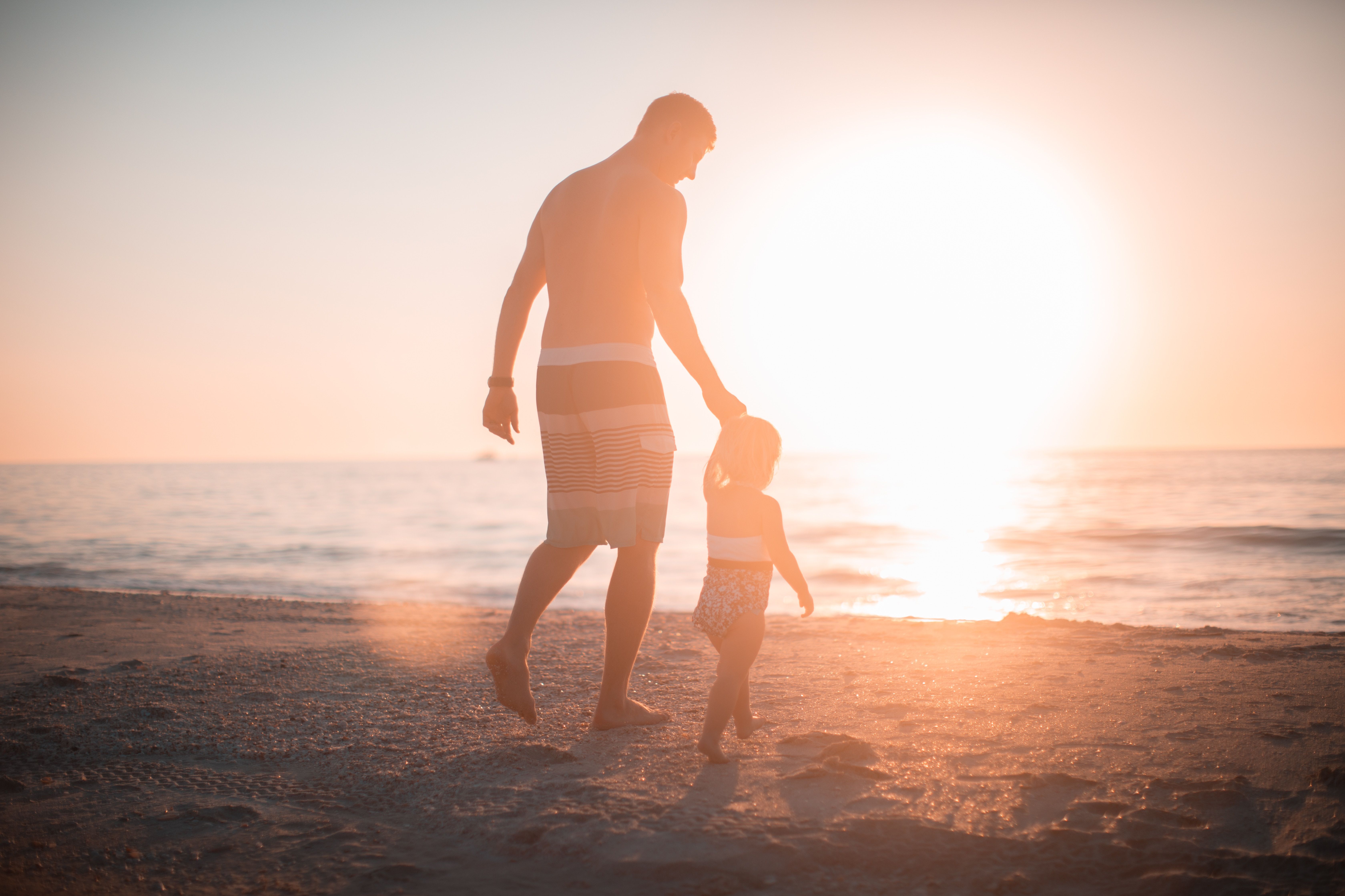 Father and child walking on the beach