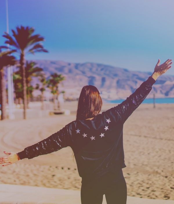 Girl on beach in leather jacket in summertime