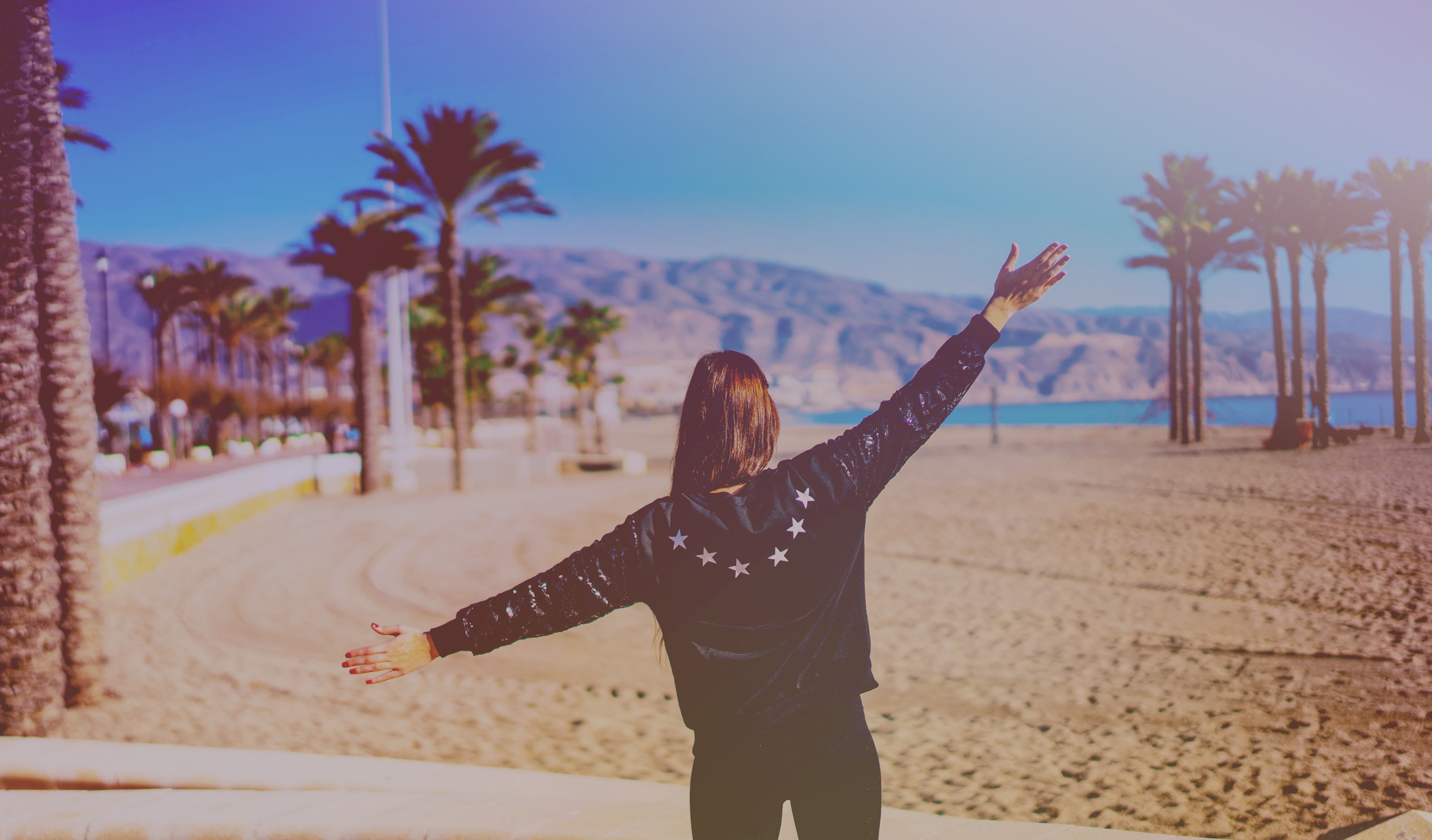 Girl on beach in leather jacket in summertime