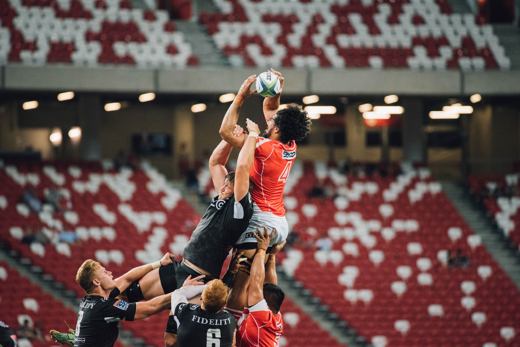 Two teams attempt to catch a rugby ball in a lineout.