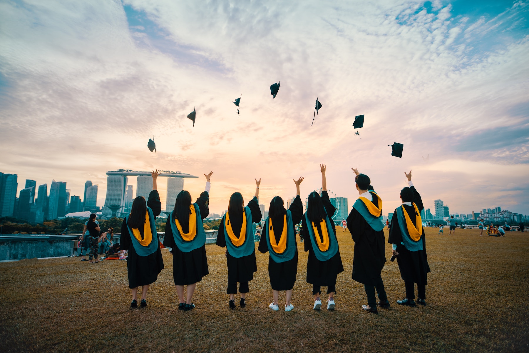 A group of people graduating and throwing their caps in the air.