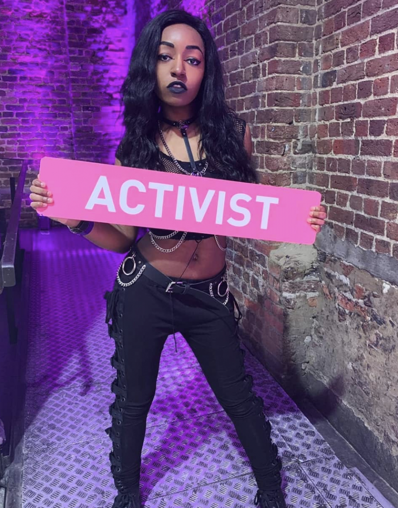 Yasmin holding a pink sign saying activist