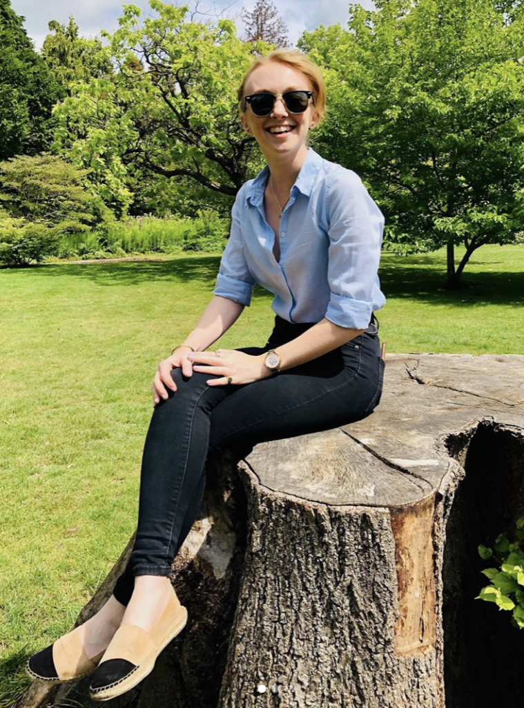 Billie sat on a log outside in summer